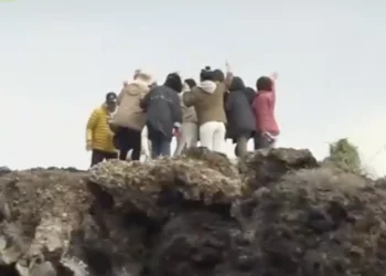 Κινέζοι τουρίστες βγάζουν φωτογραφίες σε περιοχή της Σαντορίνης όπου σημειώθηκαν κατολισθήσεις – Έκλεισε η Κόκκινη Παραλία