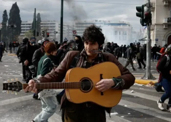 Τέμπη: Μουσικός παίζει κιθάρα εν μέσω των σοβαρών επεισοδίων με βόμβες μολότοφ και χημικά στο Σύνταγμα